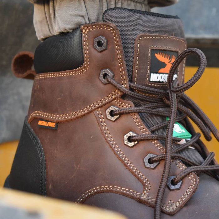 Close-up of a brown leather boot with visible brand logo on a blurred background